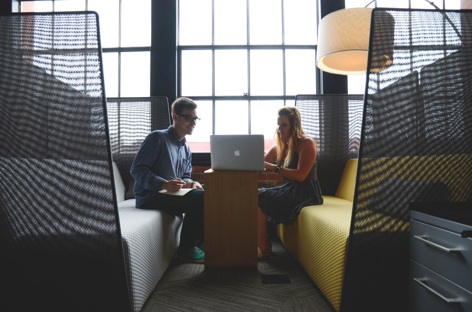 2 people looking at a laptop, discussing